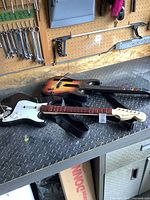 Two guitar controllers for Rock Band game systems including one Fender Stratocaster style controller.