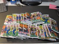 Multiple unopened 1990 Score NFL Series 1 football trading card packs arranged on a desk surface, showing various players on the wrappers.