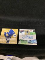 Shows Wii Sports game case next to Super Mario Galaxy Official Soundtrack CD cover on black background.