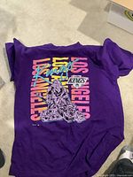 Front view of purple Los Angeles Kings 1991 T-shirt with goalie graphic and colorful text design