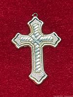 Front view of cross pendant showing diamond cut texture and overall shape