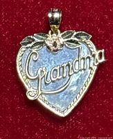 Front view of the 14k gold heart pendant with mother of pearl abalone shell and 'Grandma' script with rose gold flower detail.