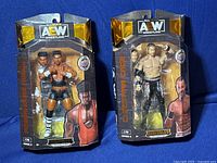 Two AEW wrestling figures in original packaging, Christian Cage and Powerhouse Hobbs, front view showing packaging and figures.