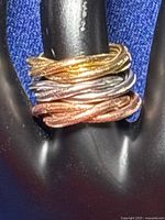 Three braided mesh loops stacked on a display stand