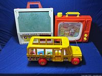 Photo of the 3 vintage Fisher Price toys including School Days Desk, School Bus, and Portable TV set.