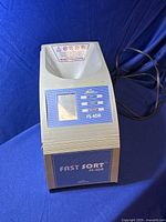Front view of Fast Sort FS-4DA coin counter machine showing coin input slot, digital display, and front panel branding.