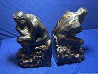 Front and back views of the two bronze bookends shaped after "The Thinker" statue showing sculpted details and aged bronze finish.