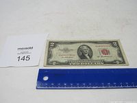 Front view of the 1953 A $2 US bill showing Thomas Jefferson and red seal with serial number.