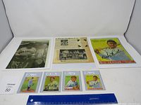 Overview of all seven items including four small cards, one oversized card, photograph and clipping