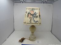 Full view of the marble table lamp with floral fabric shade plugged in, placed on a white surface with a plain background.