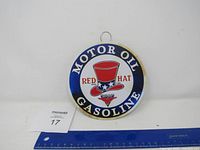 Front view of the round metal sign showing Red Hat Motor Oil Gasoline branding.