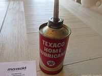 Close-up of the Texaco oil can showing label and metal spout.