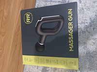 Massager gun box showing product image and branding in black and yellow design.