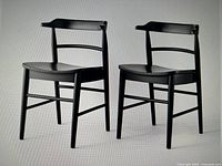 Pair of black solid wood dining chairs with curved backs and horizontal slats, front and side views.