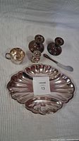 Photo showing all items in the set: two candlesticks, creamer cup, pepper shaker, butter knife, and large scalloped dish with smaller attached dish.