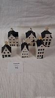 Set of six KLM Bols miniature Delft Blue ceramic houses placed on a white fabric background, showing front and side views with some chimneys visible