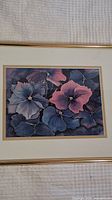 Close-up of framed floral art print with mix of blue and pink hydrangea flowers, detailed petals and soft shading.