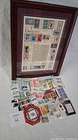 Overall view of the framed Urology stamp set alongside a spread of assorted new Canadian stamps and some Canadian Tire money.
