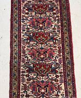 Close-up of the central medallion pattern and borders of the beige Heriz rug