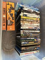 Photo shows a large box of DVDs stacked with titles visible including Mr. Bean Ultimate Collection, Deadpool, Ratatouille, Finding Nemo, and others.