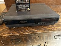 Hitachi VCR unit showing front panel with control buttons and ports.