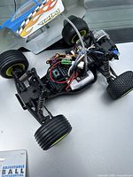 Losi Mini-T RC truck chassis with exposed electronics, brushless motor, wiring, and suspension, shown with partially transparent body shell.