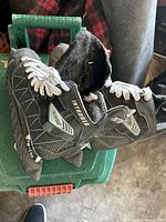 Side and top view of black Intruder inline skates with white laces and visible dust on the surface.