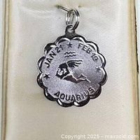 Front view of scalloped sterling silver Aquarius charm showing engraving and bail