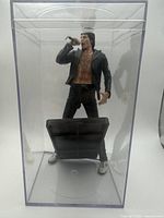 Full view of Freddie Mercury figure inside clear display case
