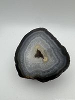 Front polished face showing grey blue cream banded agate with druzy cavity