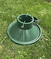 Top angle of green plastic Christmas tree stand showing eye-bolt screws and water reservoir