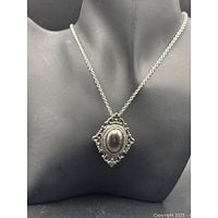 Front view of pendant on chain displayed on bust