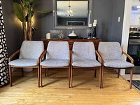 Front view of set of four teak chairs with grey chenille upholstery