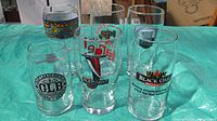 Photo showing all six beer glasses arranged on a surface, clearly displaying the brewery logos and branding.
