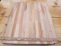 Top-down image of the butcher block cutting board showing the wood grain and smooth surface with a measuring stick showing length.
