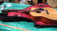 Full view of guitar laid in soft gig bag on table