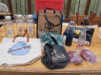 Photo of various branded beer and soda bottles and carrier bags on a table including Steam Whistle, Pepsi, Corona, Belgian Moon, Golden Corolus, Swanee, Moosehead.
