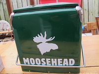 Side view of the green Moosehead cooler with white moose head logo and Moosehead text.