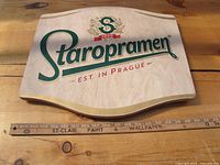 Front view of wooden Staropramen beer sign showing logo and size