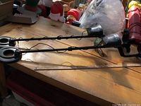 Two assembled metal detectors on wooden table with measuring stick