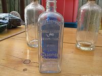 Close-up of clear rectangular bottle embossed with "Champion Company".