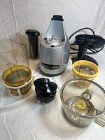 All components of the Omega juice extractor including motor base, strainers, feeding chute, pusher, and juice/pulp containers.