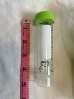 Single VWR centrifuge tube, showing 50 ml measurement marking, green screw cap, and clear plastic body next to a pink measuring tape for scale, approximately 5.5 inches tall.