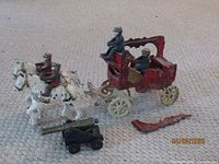 Full view of the cast iron wagon pulled by two horses with four riders and cannon on side