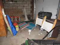 Photo showing all beach chairs, beach umbrella, and sand toys on floor in garage.