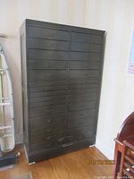 Front view of black wooden cabinet with 30 drawers