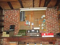 Workbench pegboard with hanging tools and toolboxes on the wooden bench including green and red metal tool boxes and Sears Craftsman box