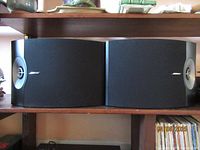 Pair of black Bose 301-V speakers with curved sides and Bose logo front