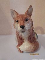 Front view of fox-shaped ceramic pitcher showing face and body details.