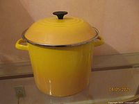 Full view of yellow Le Creuset covered pot, showing front and lid.